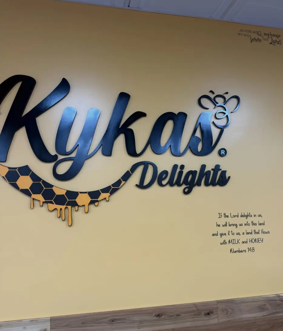 The Kykas Delights wall with the shop name and hand-lettered Bible verses