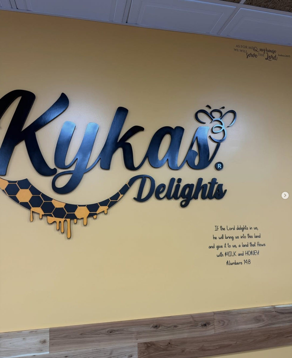 The Kyka’s Delights bee and honeycomb sign inside the yellow White Plains shop